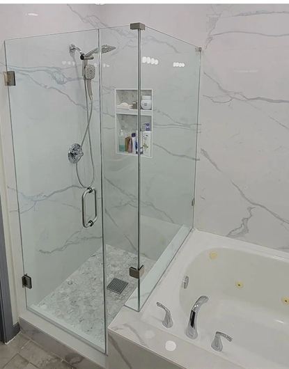 L-shaped frameless shower door with white tile installed in a Miami home