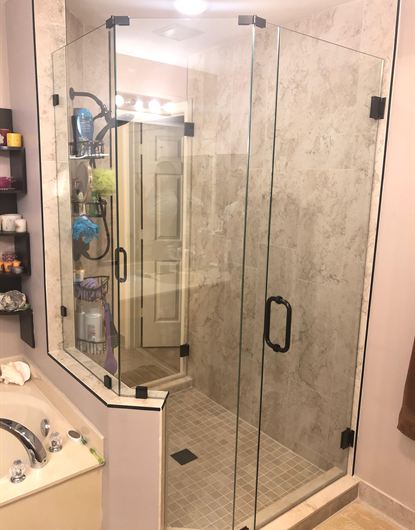 Neo-angle black frameless shower door installed in a Hollywood, FL home